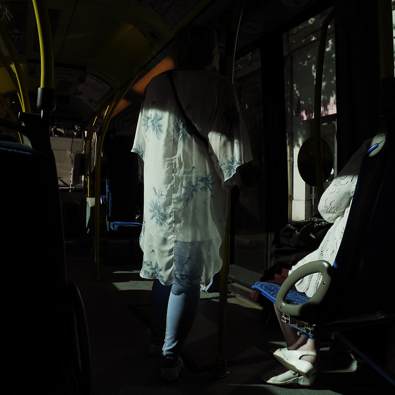 le vêtement d'une femme à fleur bleue dans la lumière d'un bus